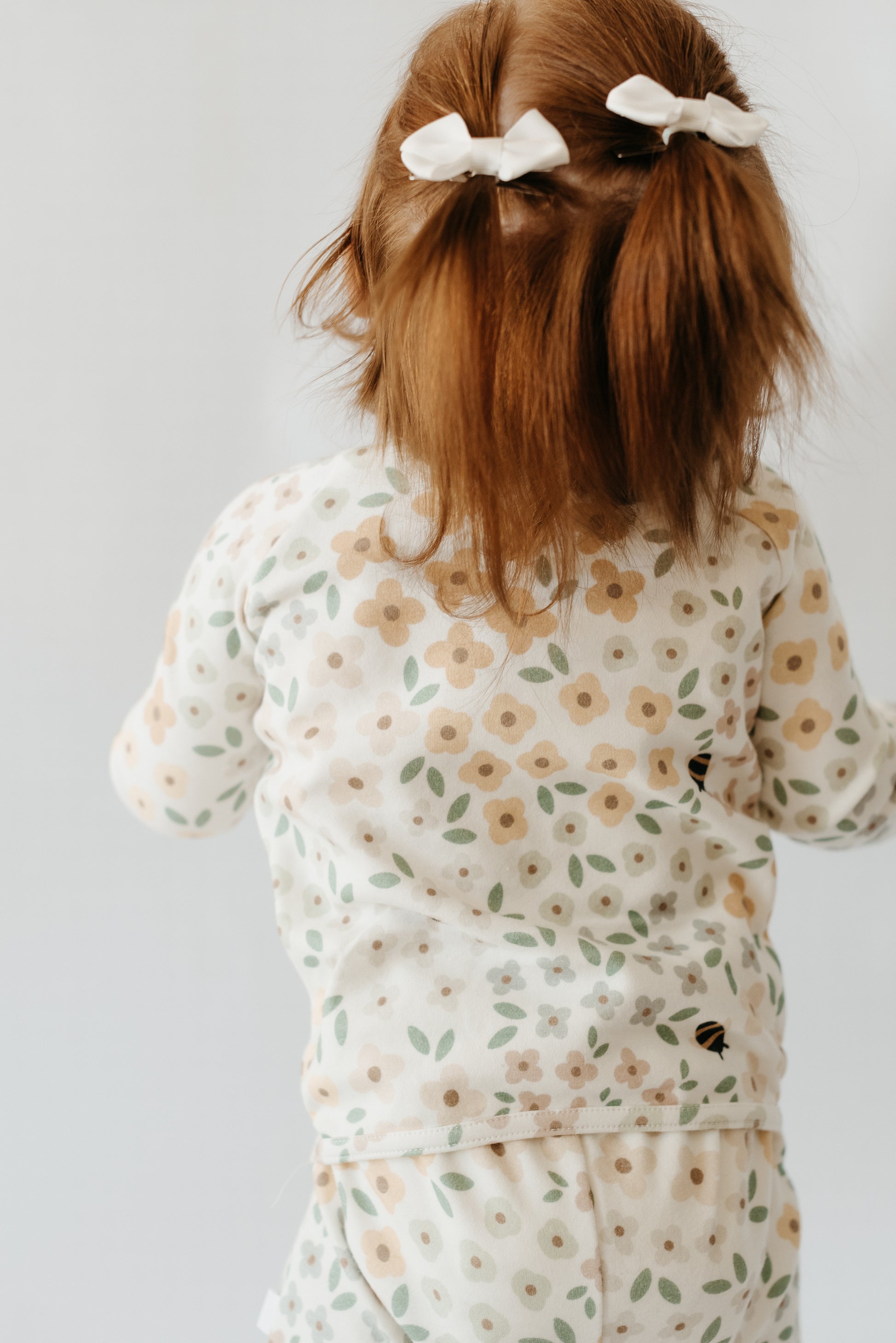 Close-up of LURE by Lina floral design baby sleeper — Diaper Peek-a-Boo zipper, soft stretch cotton fabric, and fold-over mittens for newborn girls