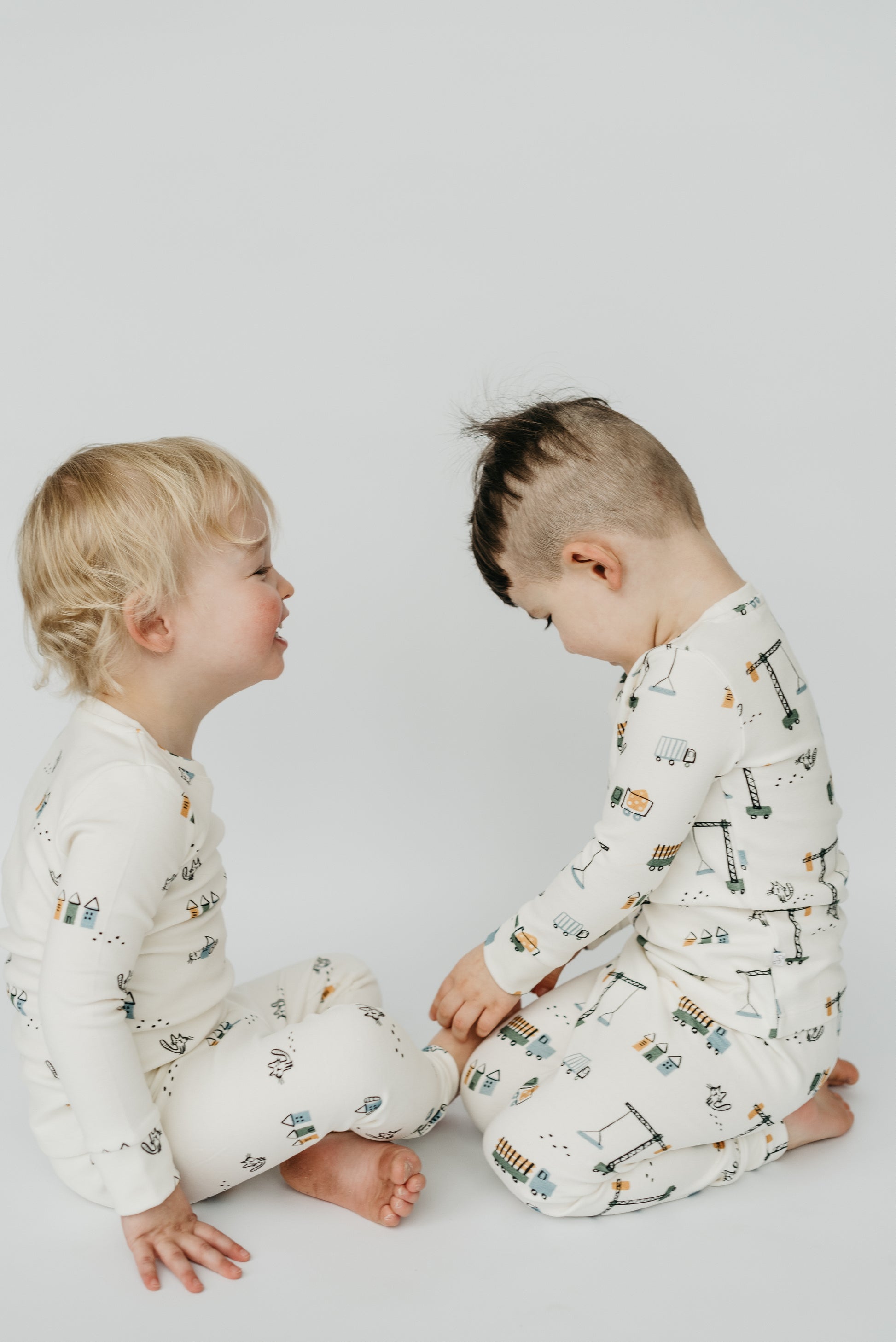 Baby and toddler wearing LURE by Lina matching pajamas — soft cotton blend Play Time print sleepwear for siblings