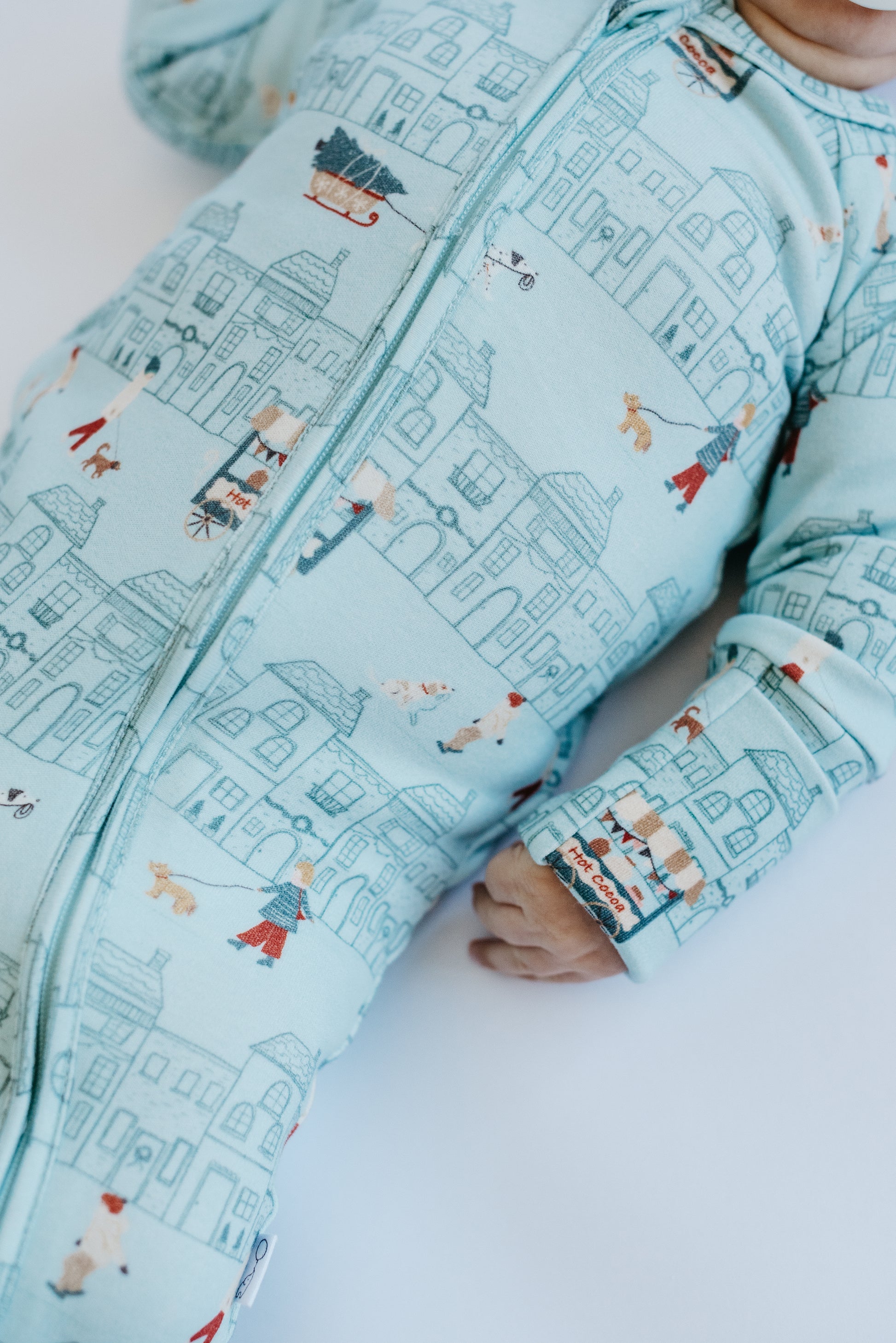 Neutral aqua baby zip footie — LURE by Lina Merry Little Street print, two-way zip, double-stitched neckline.