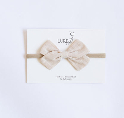 LURE by Lina Organic Cotton Bow in Sandstone — soft beige baby headband made from organic cotton knit and gentle nylon band