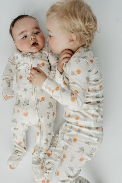 Sibling matching set in Play Time print — infant sleeper and toddler two-piece pajamas made from soft, breathable cotton blend by LURE by Lina