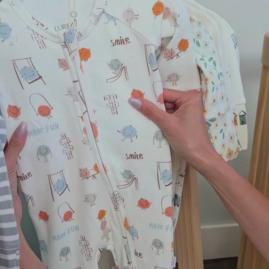 Matching baby and toddler pajamas in the Play Time print by LURE by Lina. Soft cotton blend, Diaper Peek-a-Boo zipper, and cozy comfort for all ages.